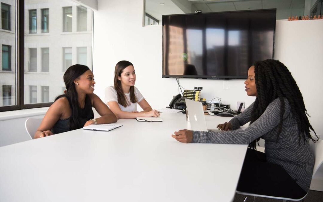 three women talking in an office conference room